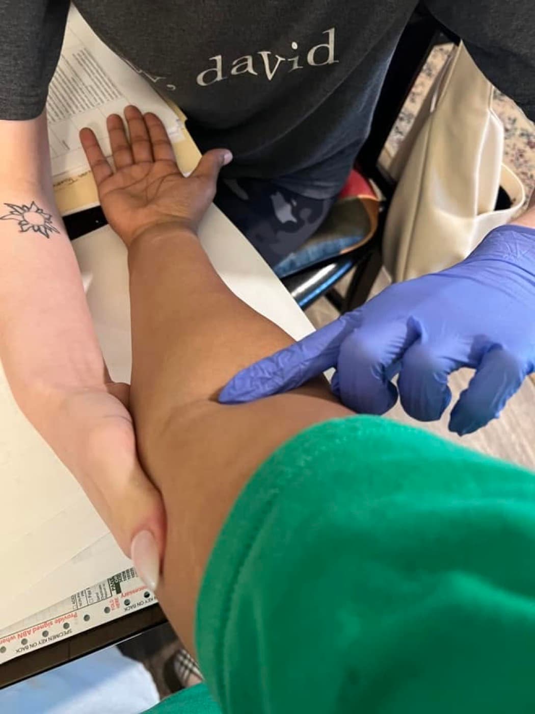 A certified mobile phlebotomist performing a gentle blood draw for a senior patient at home